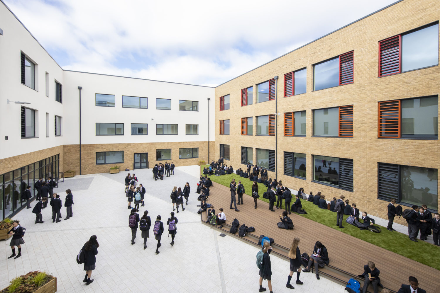 Photo showing the outside of the Leigh Academy Blackheath building, including a large group of students enjoying their break time.
