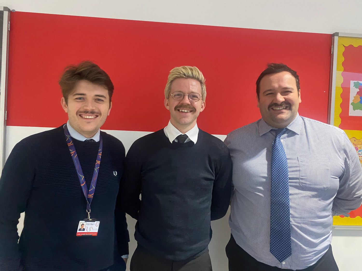 Three male staff members are seen posing together for a photo showing off the moustaches they have grown in support of 'Movember'.