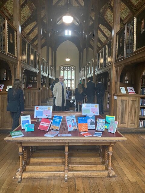 A photo of the Library at Oxford University, featuring a table with various books on it in the foreground.