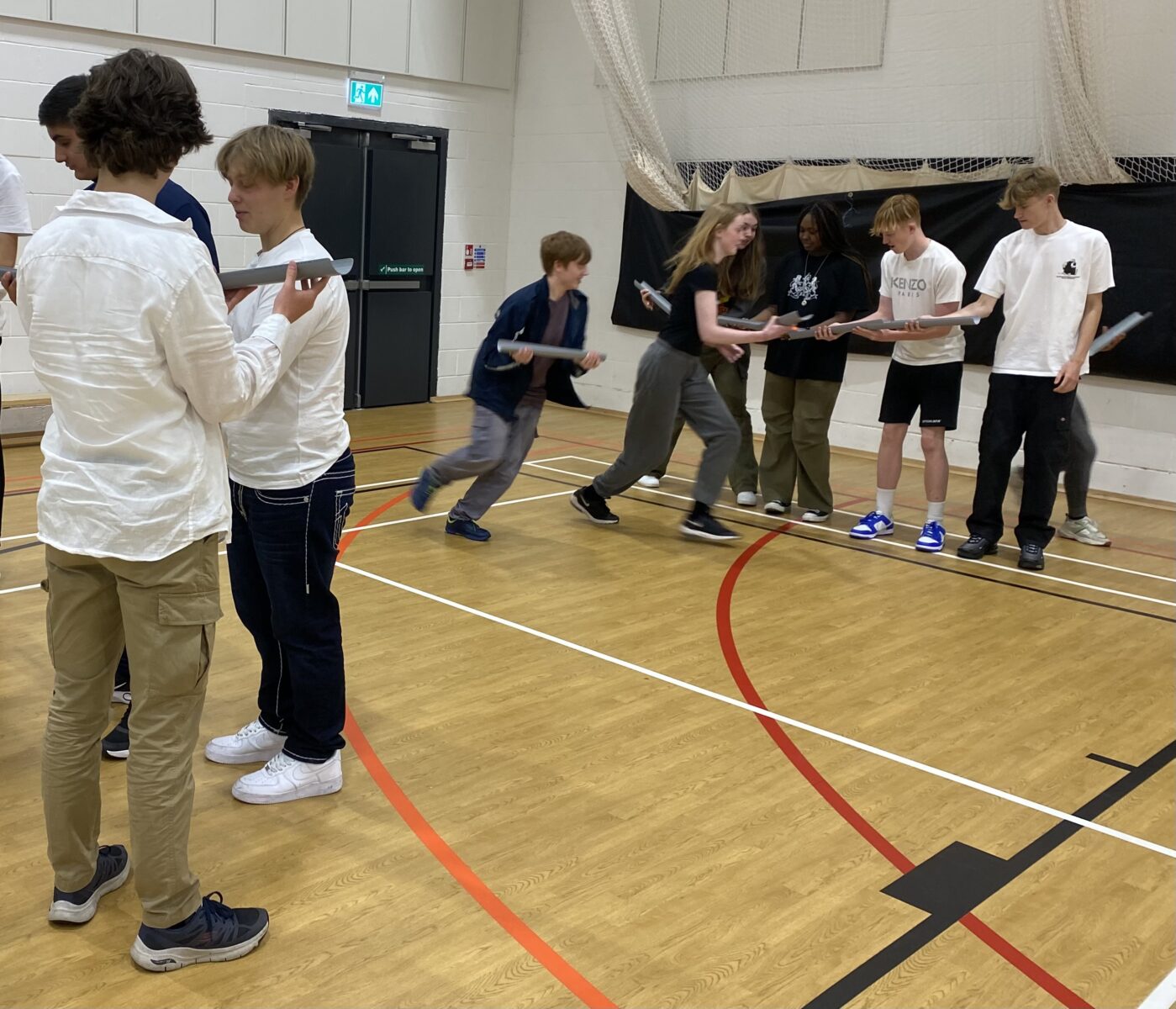 Students partaking in a team building activity in a sports hall