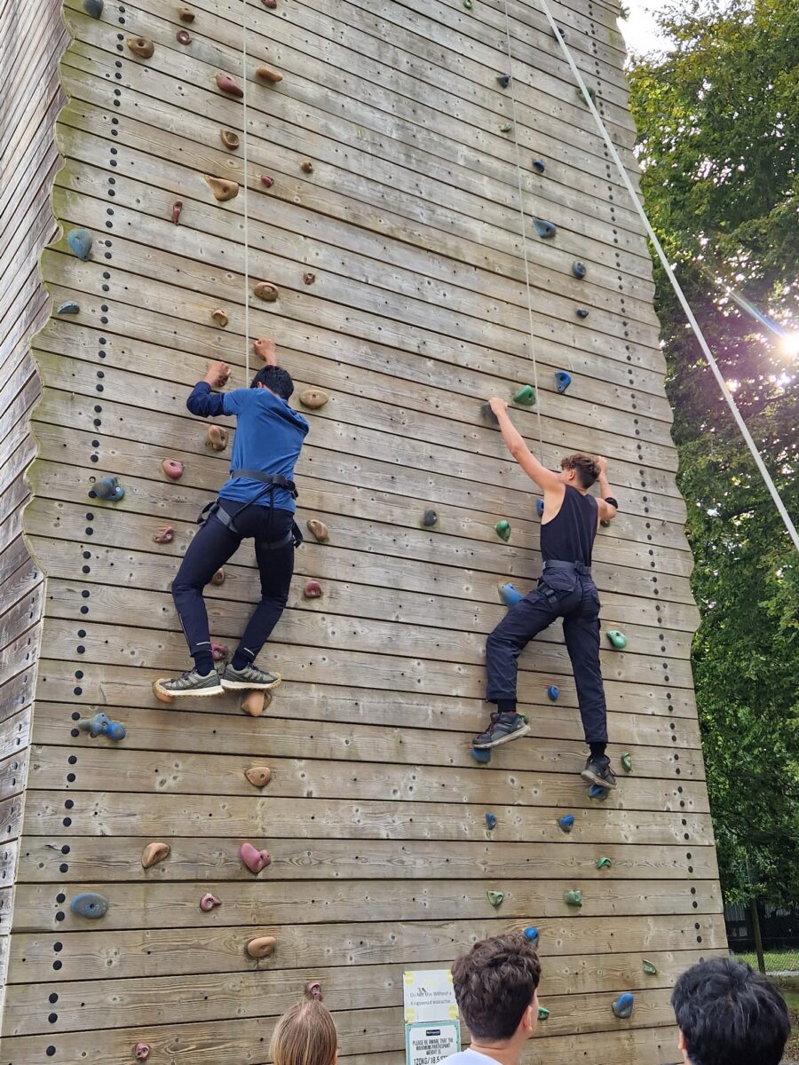 2 students on a rock climbing wall